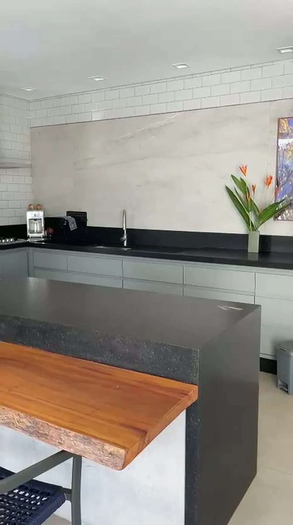 Ilha gourmet planejada com bancada em granito e mesa de madeira maciça